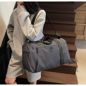 Detail view of large dark grey travel bag with wide handles and adjustable strap