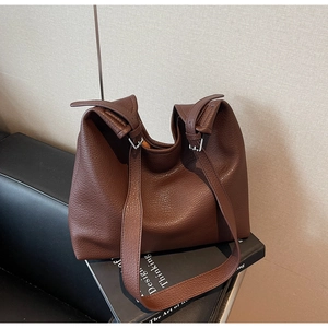 Detail of dark brown lychee grain leather tote with adjustable silver metal buckles