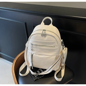 Detail of cream white lychee leather backpack with woven straps and coin purse