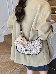 Fashionable beige plaid crescent bag with black leather trim and cute plush rabbit charm