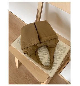 Detailed view of brown nylon puffer tote bag with large double front pockets on a chair