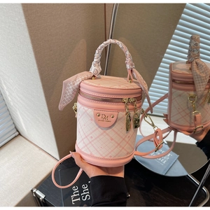 Detailed shot of pink bucket bag with quilted patterns, scarf handle and gold hardware