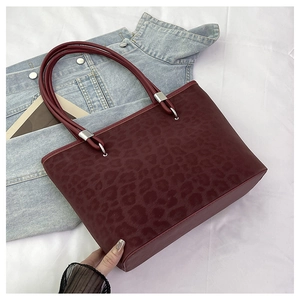 Dettaglio della borsa tote leopardata di alta qualità in pelle rosso scuro