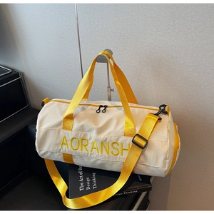 Detail of white canvas gym bag with yellow AORANSH embroidery and adjustable straps