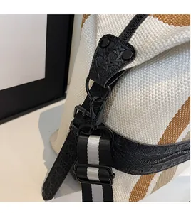 Detail of adjustable striped shoulder strap with durable matte black metal hooks