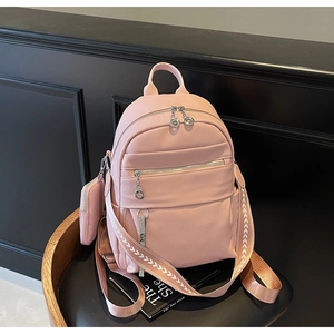 Detailed macro view of pink lychee leather texture and jacquard strap on a stylish backpack