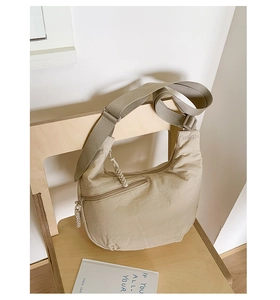 Detail of WISDORA beige crescent bag with textured fabric and woven zipper pull