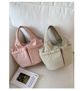 Close-up of quilted bubble tote bags in pink and beige on a cozy sofa setting