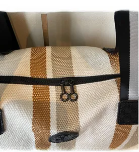 Close-up of smooth double zipper and woven striped fabric texture on the travel bag