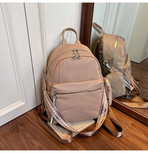 Detail of apricot pebbled leather backpack with geometric woven strap and mirror reflection