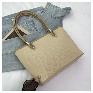 Dettaglio borsa tote beige con stampa leopardata e finiture in metallo argento
