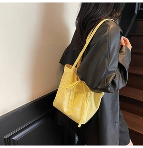 Detail of yellow canvas tote bag featuring 'Rise and shine' print with tie closure