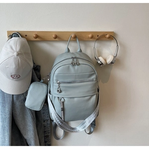 Detail view of blue faux leather backpack with litchi texture and matching coin pouch