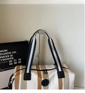Detail of striped travel bag featuring sturdy woven handles and secure zipper closure