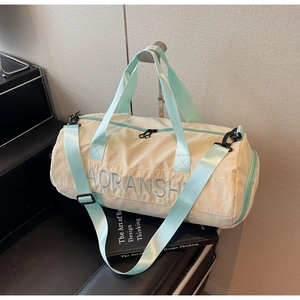 Detail of travel duffel bag showing durable nylon fabric and mint green shoulder strap