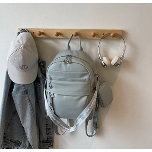 Close-up of light blue PU leather backpack with mini pouch and arrow pattern strap