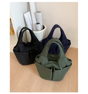 Detailed view of large capacity tote bags in black, navy, and dark green with multi-pockets