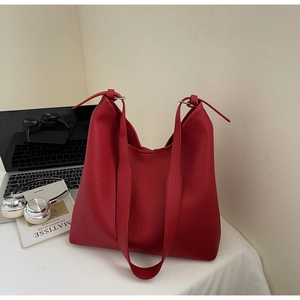 Detail of red hobo bag with pebble leather texture and silver buckle for daily commute