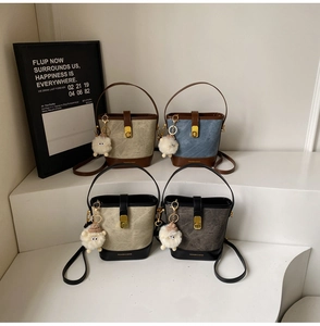 Détail de quatre sacs seaux texturés vintage avec breloques mouton en peluche et bandoulières