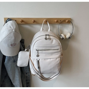 Detailed macro view of white lychee texture leather backpack with geometric pattern strap