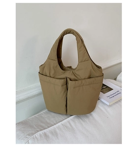 Detail view of khaki quilted nylon tote bag with functional large front pockets