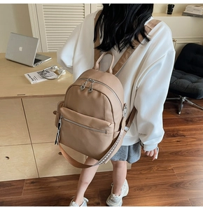 Detail view of khaki textured leather backpack with stylish patterned shoulder straps