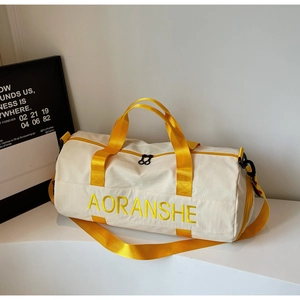 Detail of travel bag showing yellow straps, contrast handles and dual zipper closure