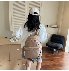 Detail of camel faux leather backpack with geometric pattern strap in an office setting