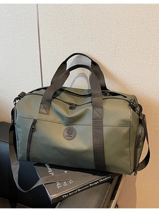 Olive green travel duffel bag with waterproof nylon fabric and adjustable shoulder strap