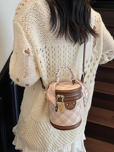 Elegant checkered bucket bag with silk scarf handle detail and adjustable leather strap