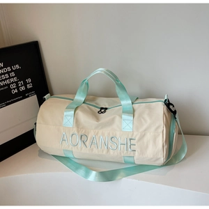 Detail of beige travel bag showing mint green straps and high quality woven fabric texture