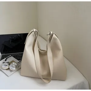Close-up of cream white tote bag in premium lychee grain texture on a minimalist desk