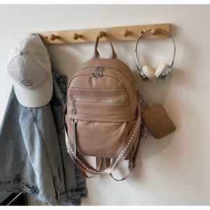 Close-up of lychee grain leather backpack with woven straps and matching small pouch
