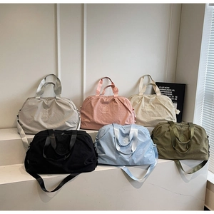 Multiple colors of large capacity travel bags displayed on minimalist white stairs