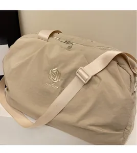 Detail of beige travel bag with NINGJIA embroidery and adjustable shoulder strap