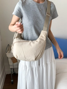 Minimalist beige nylon crescent crossbody bag with adjustable wide strap for daily commute
