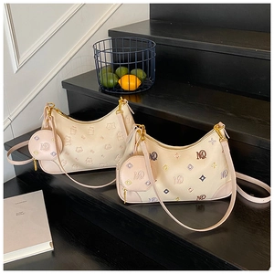 Detail of cream hobo bag with cat embossing and matching round coin purse on steps