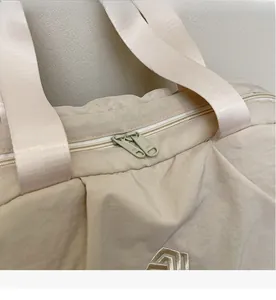 Macro shot of durable beige travel bag with high-quality dual SBS zippers and embroidered logo