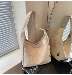 Detail of minimalist beige canvas tote bag with side label in natural window sunlight