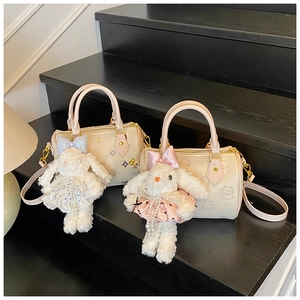 Detailed view of mini bucket bags with cute rabbit charms and gold hardware on stairs