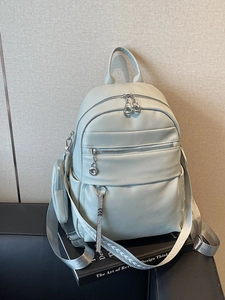 Light blue faux leather backpack with wide patterned strap and matching small pouch