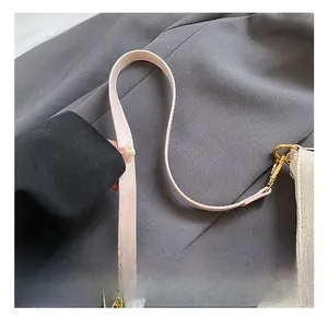 Detail of white pebbled leather bag with pink cat embroidery and gold-tone hardware hook
