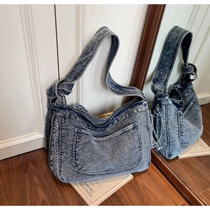 Detail of snowflake washed denim hobo bag with knotted shoulder strap and side pocket