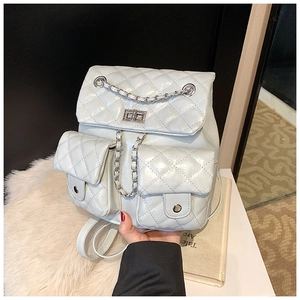 Detail of light gray quilted backpack with chain straps and silver twist lock closure