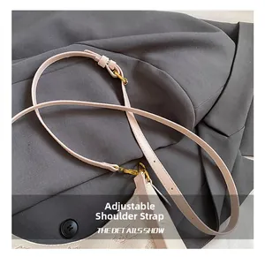 Detail of adjustable synthetic leather strap with gold hardware and pink cat pattern