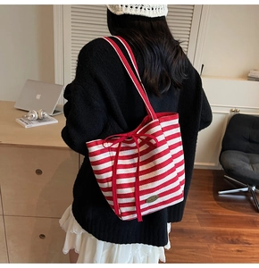 Detail of red and white striped canvas tote with bow and handmade metal plate