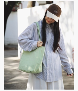 Detail of mint green canvas tote bag showing large capacity and thick cotton texture