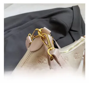 Close-up of premium metal hook and pink cat embroidery on lychee grain leather bag