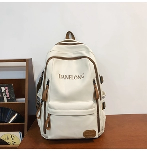 Macro shot of ivory large-capacity backpack detail featuring brown leather accents