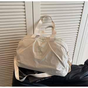 Detail of cream travel bag with NINGJIA embroidery and adjustable shoulder strap